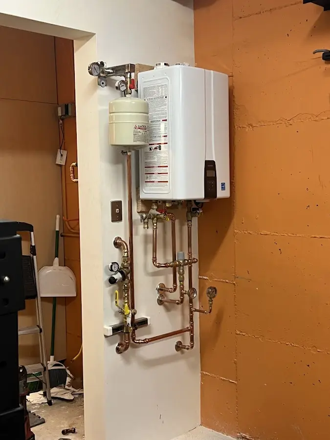 Plumbing technician inspecting water heater connections in Buckhannon